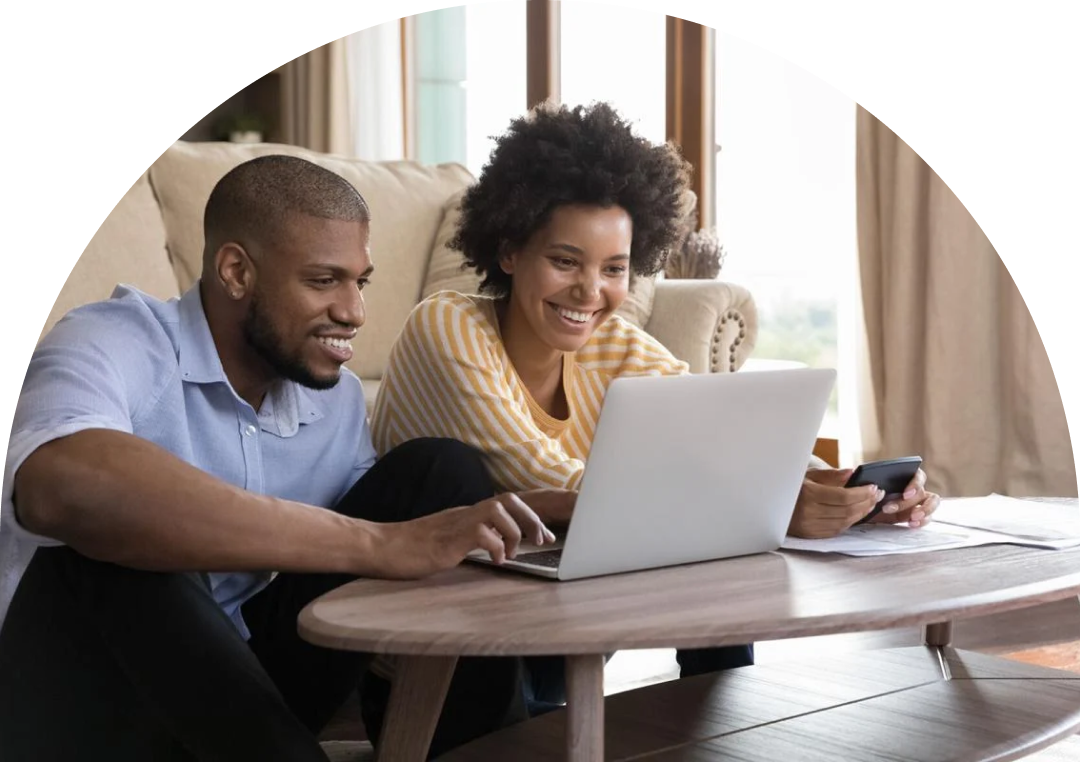 A person with long hair wearing glasses is sitting at a desk, looking at a laptop screen, and biting a yellow pencil in frustration. There is a cup filled with colored pencils in the foreground.