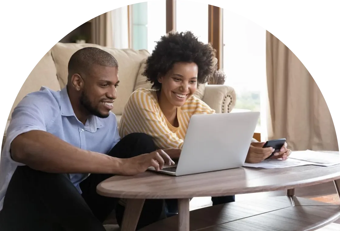 A person with long hair wearing glasses is sitting at a desk, looking at a laptop screen, and biting a yellow pencil in frustration. There is a cup filled with colored pencils in the foreground.