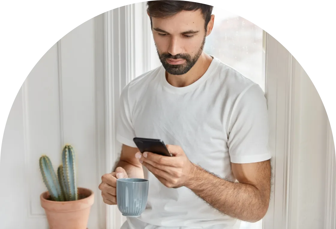 A hand holding a magnifying glass over white tiles spelling out the word 'FRAUD' on a white background. The magnifying glass enlarges the letter 'F' in the word.